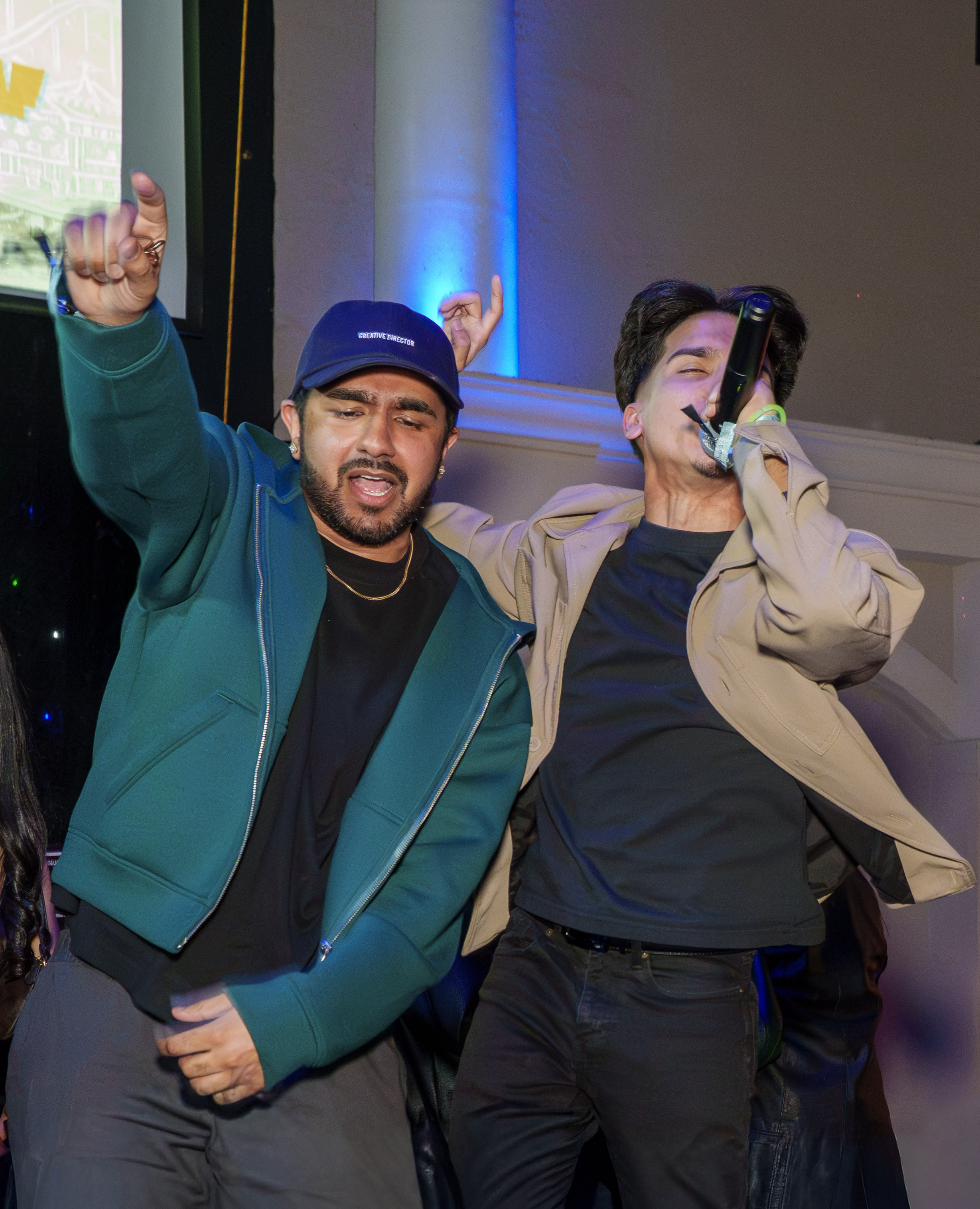 Two hosts performing together with a microphone at a club event