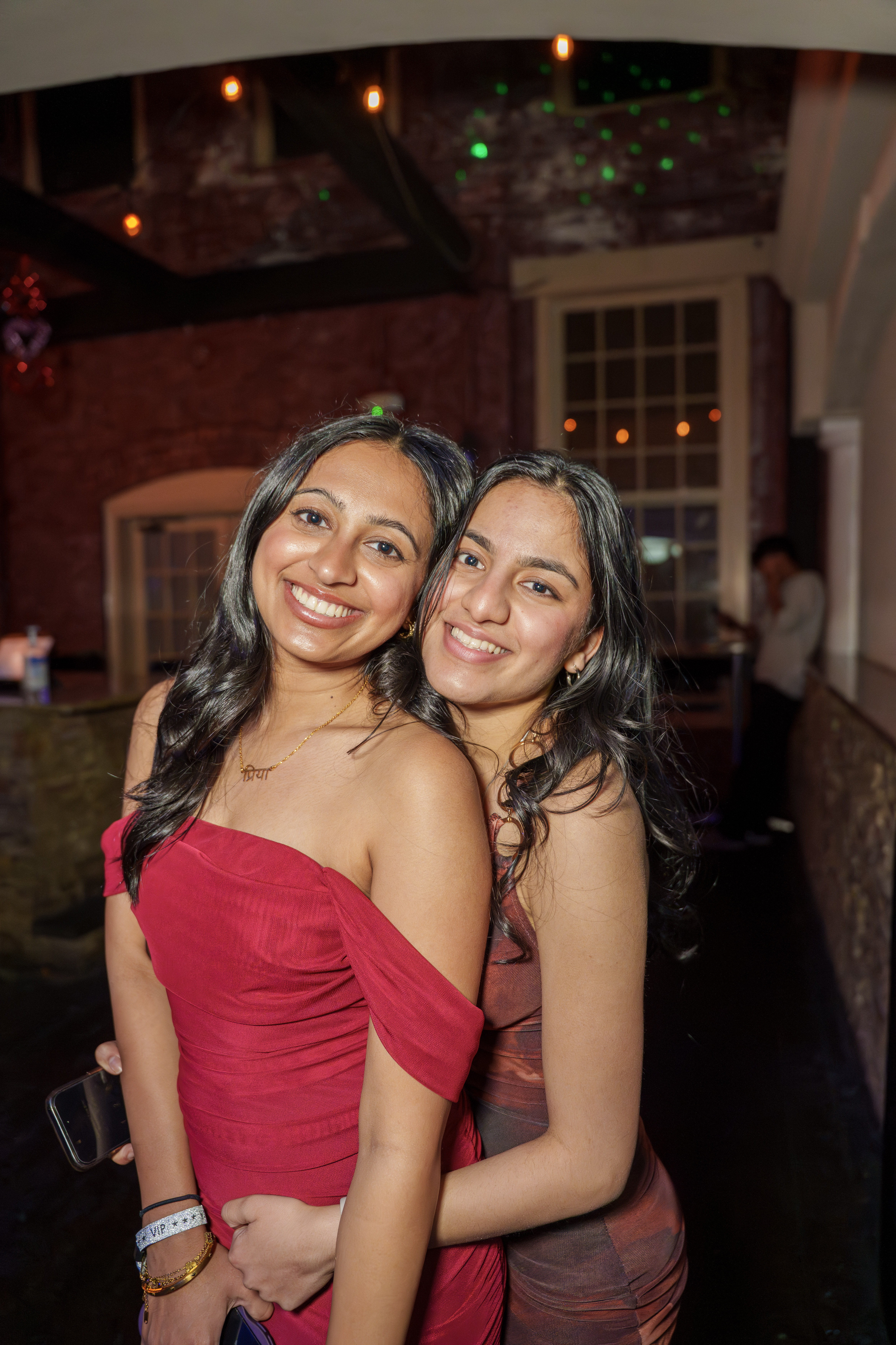 Two friends smiling together for a portrait at a nightlife event
