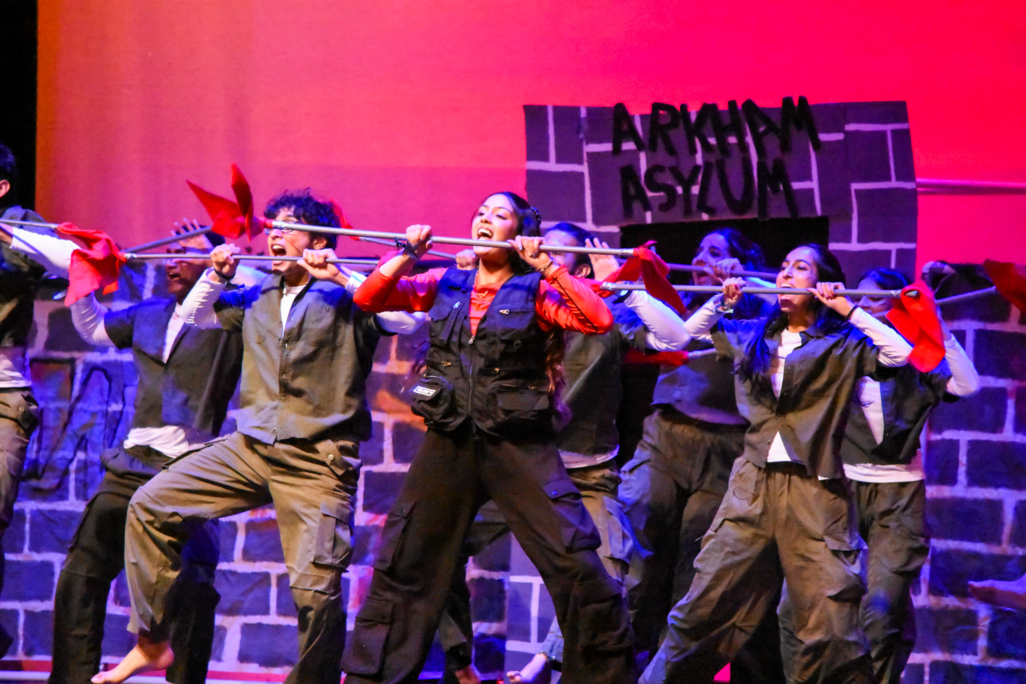Dance ensemble performing with red flags during a cultural showcase