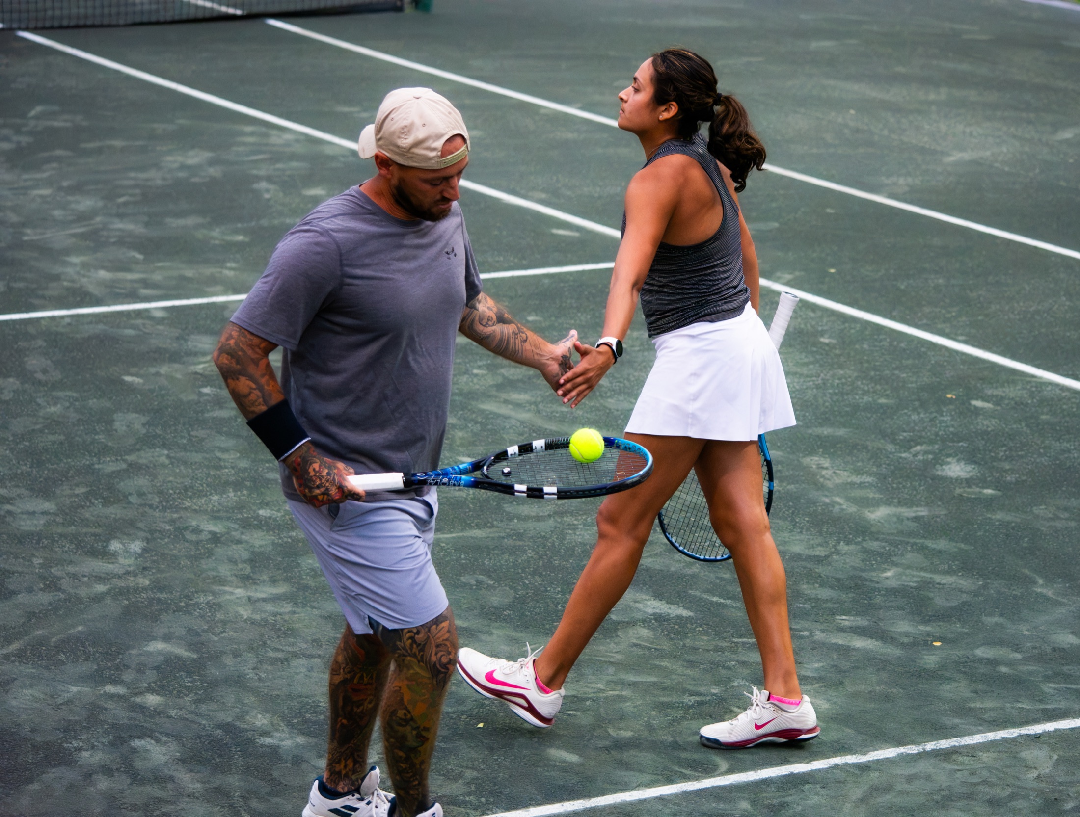 Mixed doubles partners exchanging a celebratory high five on court