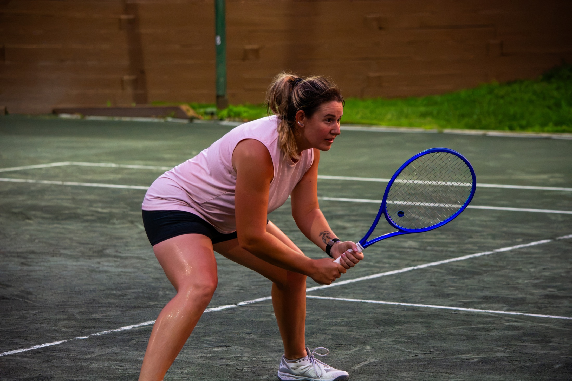 Tennis player in pink focused in a ready position before the next point