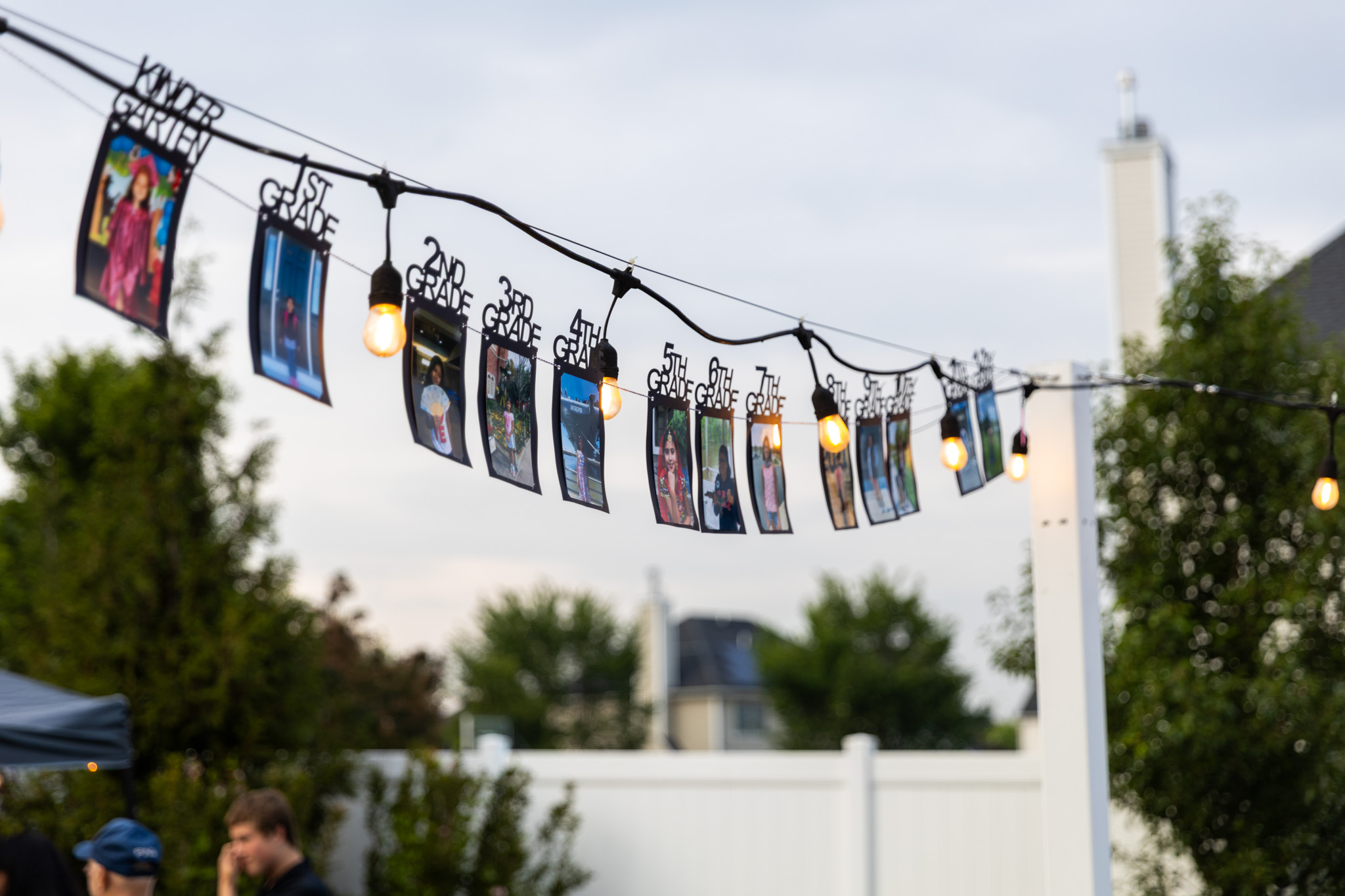 Graduation photo memories hanging between warm string lights