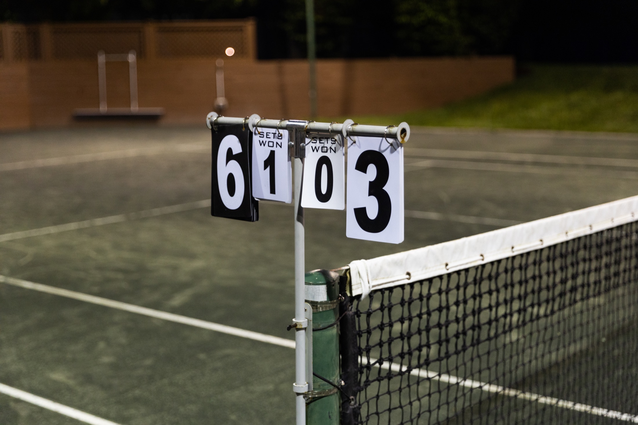 Match scoreboard beside the tennis net at the end of tournament play