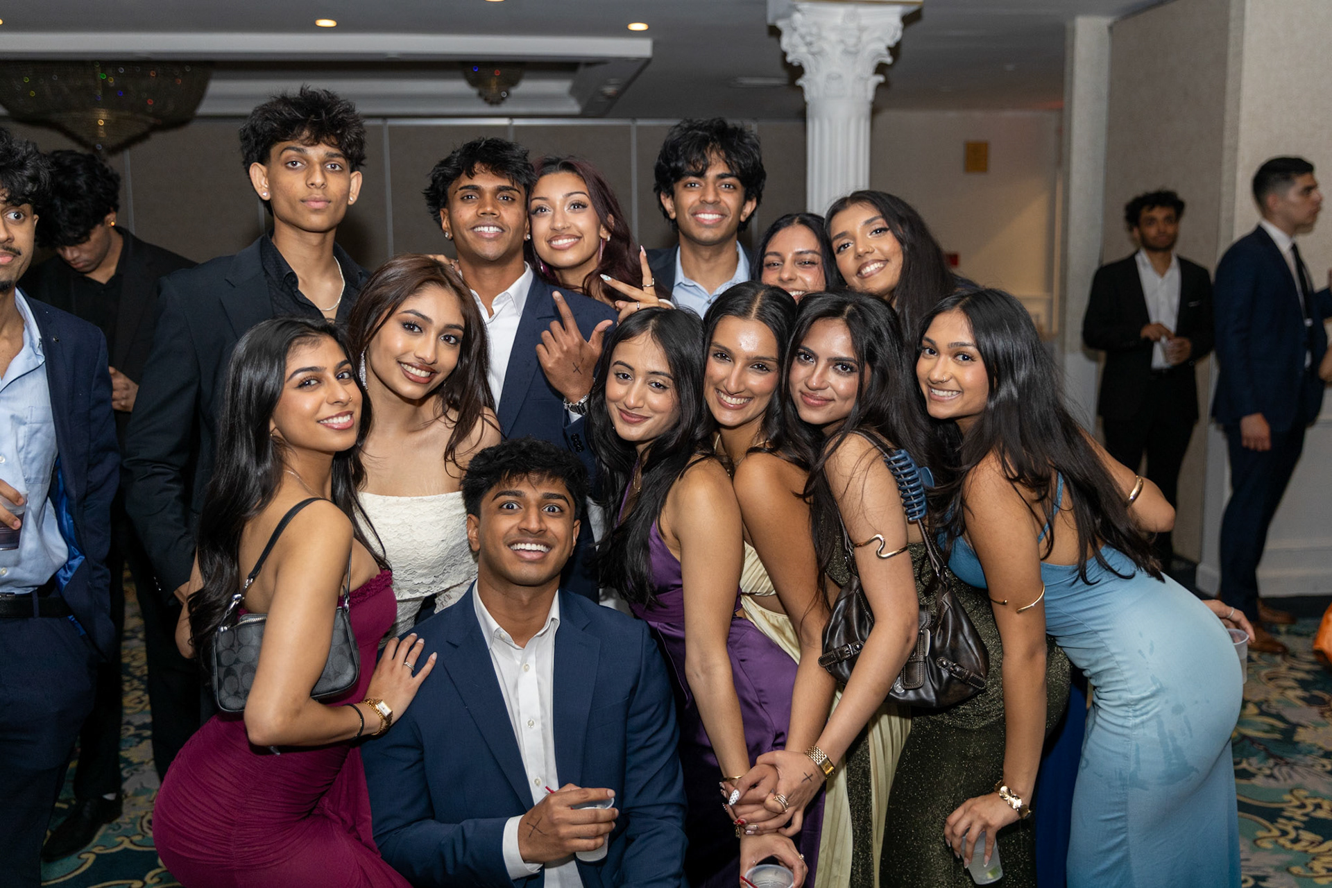 Large group of friends posing together at a formal nightlife event